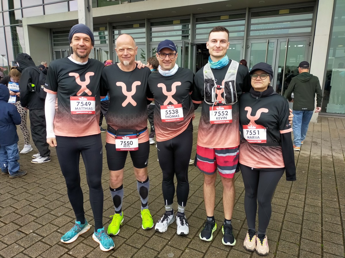 Fünf Läufer des Teams DORNER stehen nebeneinander vor der Messehalle.